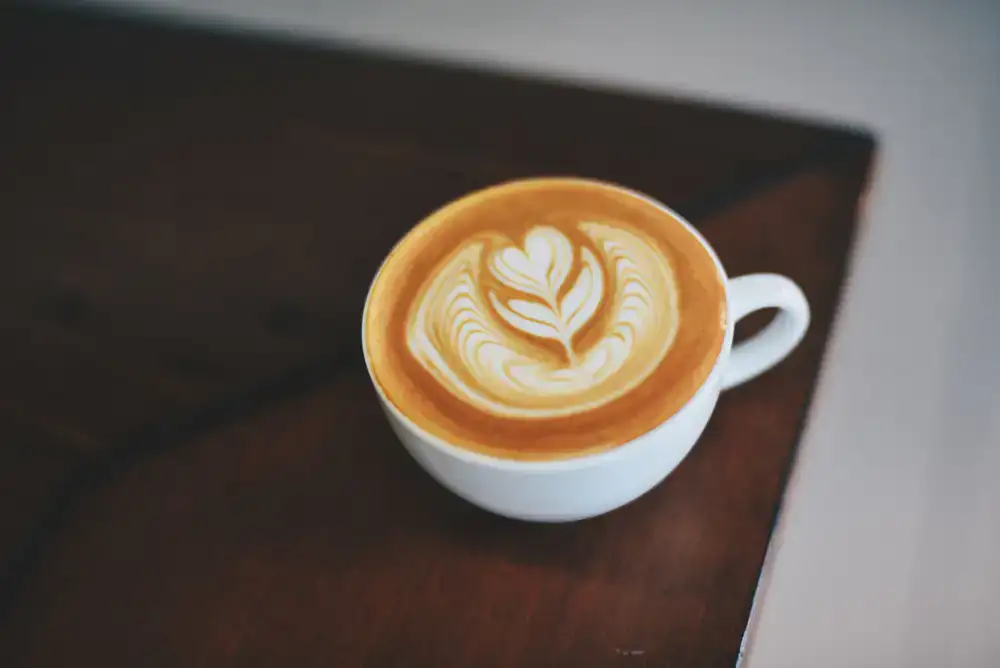 Barista gießt Latte Art in eine Tasse